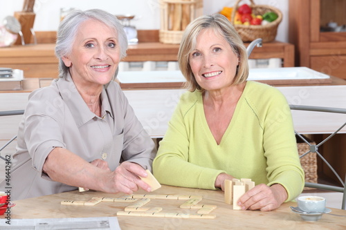 duo of retired ladies playing scrabble in the kitchen