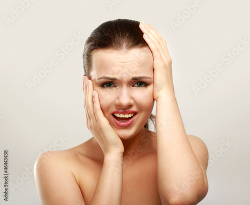 Young woman with head pain on white background
