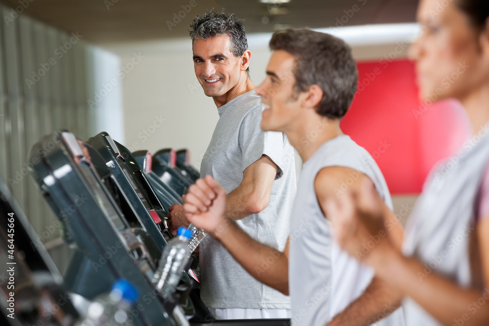 Man Running On Treadmill In Fitness Club