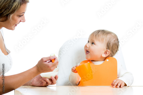 mother spoon feeding her ba...