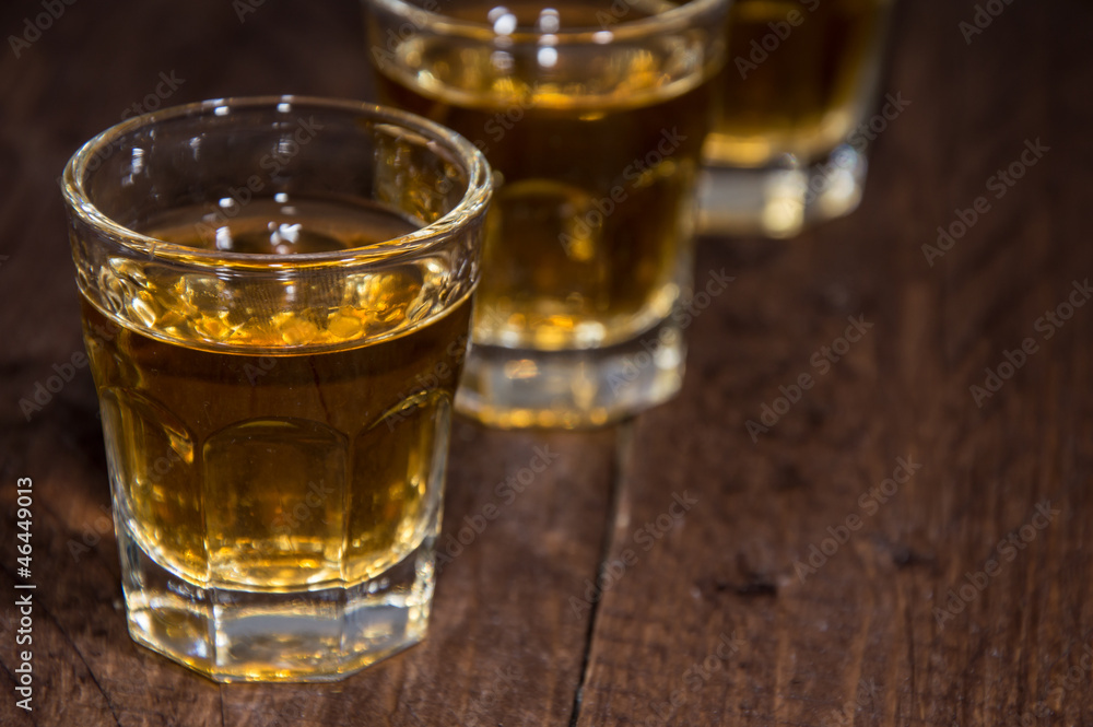 Line of Rum Shots on wooden background Line of Rum Shots on wooden background