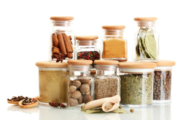 Fototapete Gewürze jars and wooden spoons with spices isolated on white  © Africa Studio