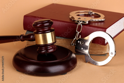 Gavel, handcuffs and.book on law on beige background