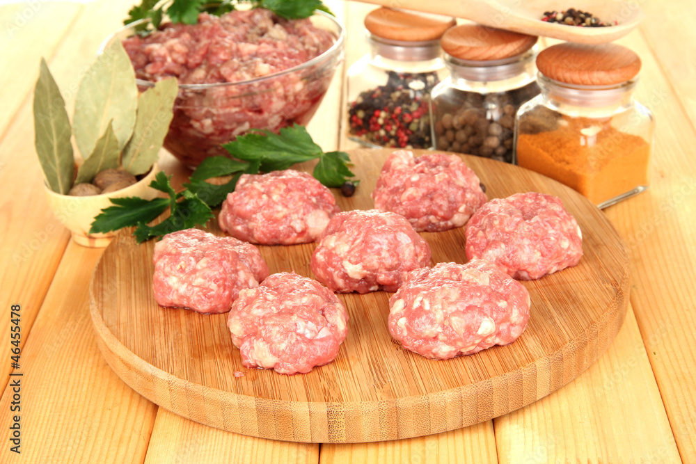 Raw meatballs with spices on wooden table Raw meatballs with spices on wooden table