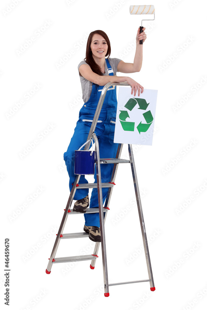 Tradeswoman holding a paint roller and a poster Tradeswoman holding a paint roller and a poster