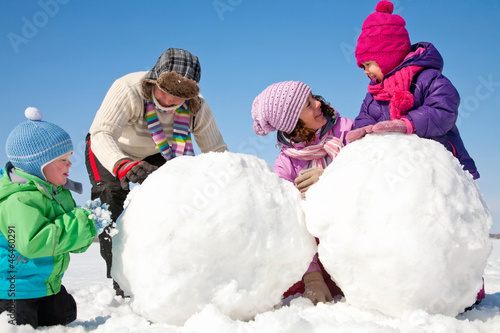 Happy family making snowman