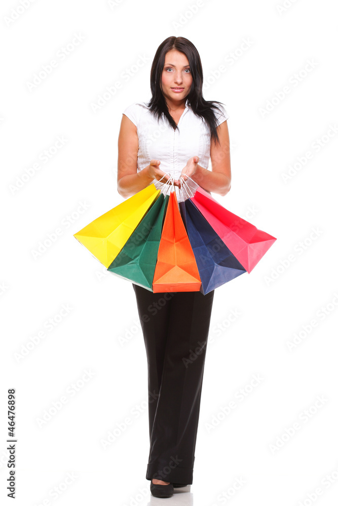 Portrait of young woman carrying shopping bags against white bac Portrait of young woman carrying shopping bags against white bac