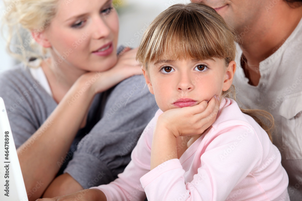 Bored little girl sat with her parents Bored little girl sat with her parents