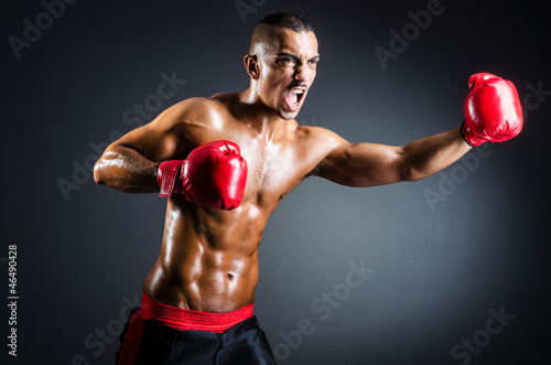 Boxer with red gloves in dark room © Elnur