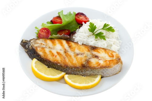 grilled fish with boiled rice on the plate on white background