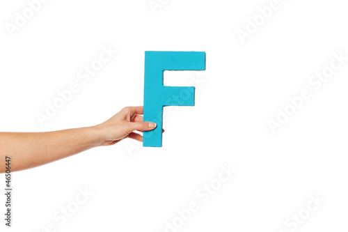 hand holding up the letter F from the left