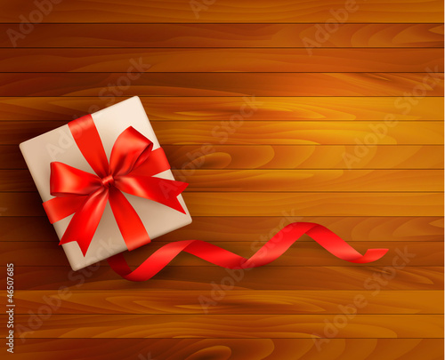 Holiday background with gift box and red ribbons.