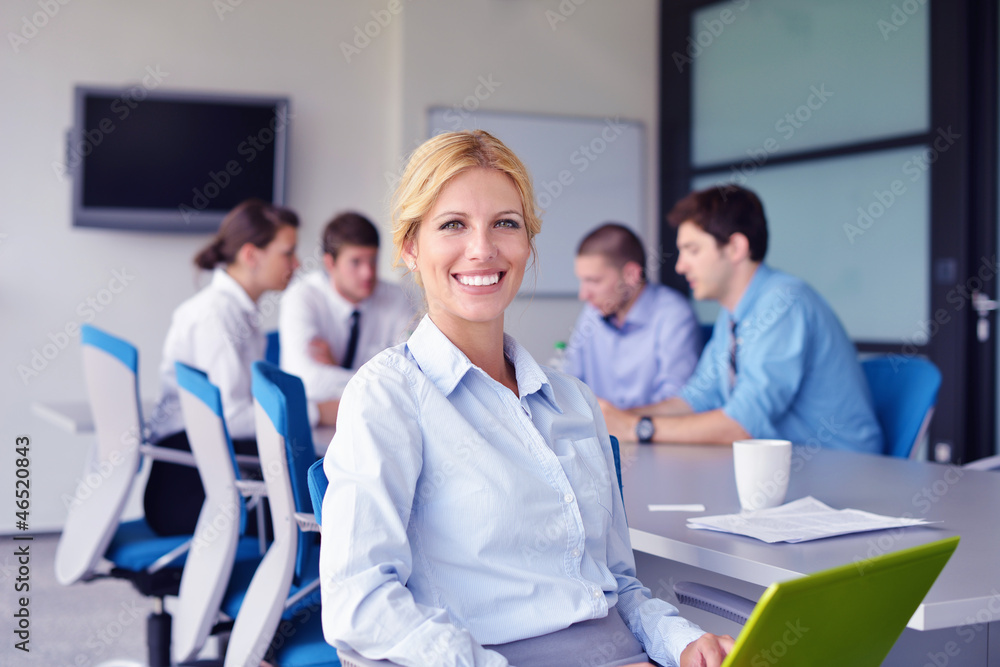 business woman with her staff in background at office