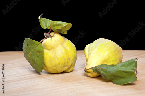 Fresh quinces on a wooden board