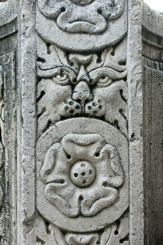 ornate venetian water well in corfu with carved lions head and tudor rose flower