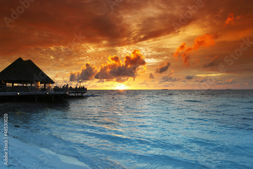 Beach and tropical houses on sunset