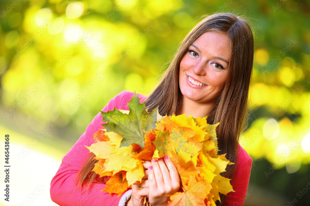 Naklejka premium Autumn woman on leafs background