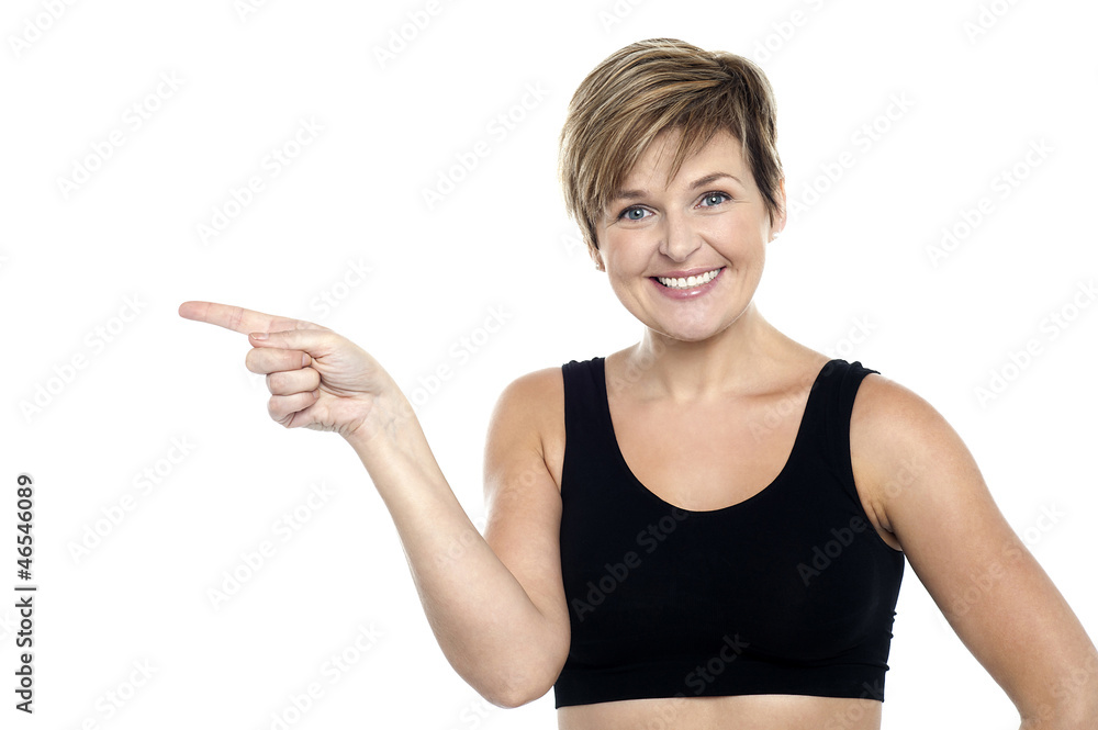 Cheerful middle aged woman pointing at copy space area Cheerful middle aged woman pointing at copy space area