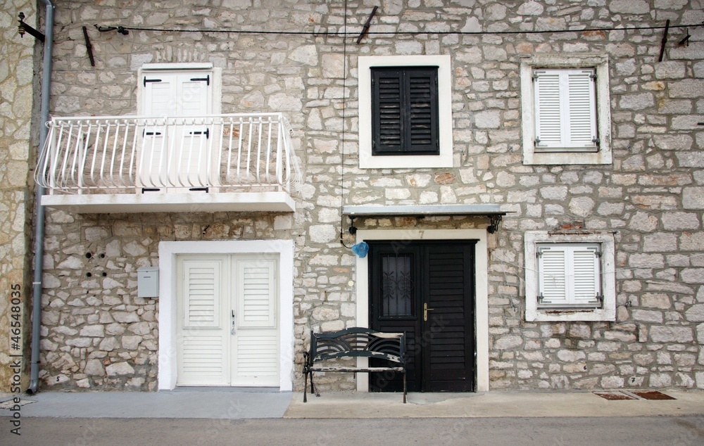 Old stone house with shutters in front view