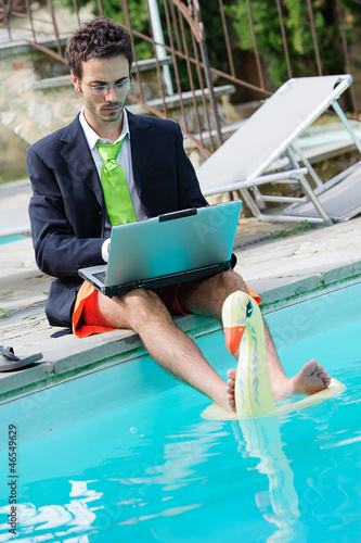 Funny Young Businessman with SwimmingTrunks next to the Pool photo