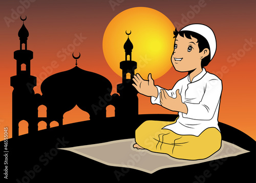 A boy praying with silhouette mosque background