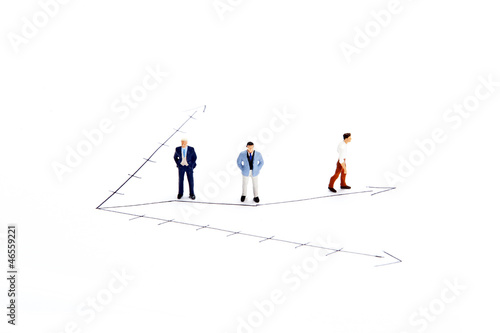 Miniature people on white with some diagrams