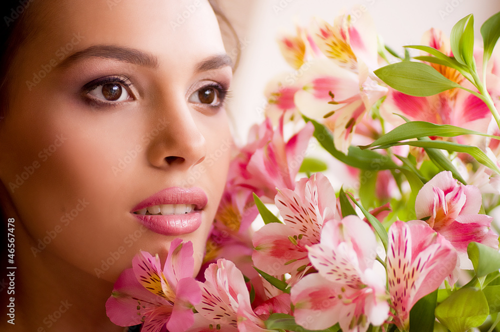 Beauty face of the young woman with pink flowers
