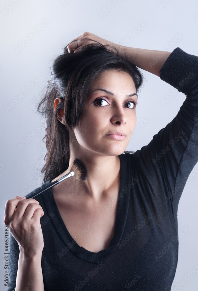 Obraz premium woman applying foundation powder or blush with makeup brush