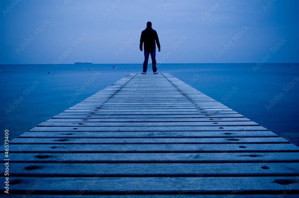 Man standing on a wooden pier