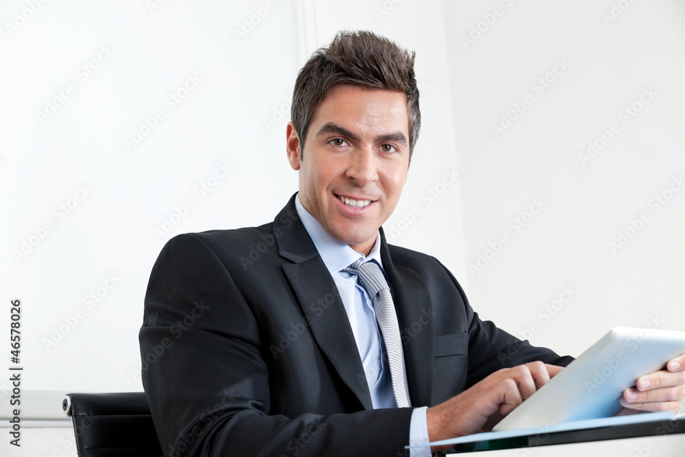 Young Businessman Using Digital Tablet In Office Young Businessman Using Digital Tablet In Office