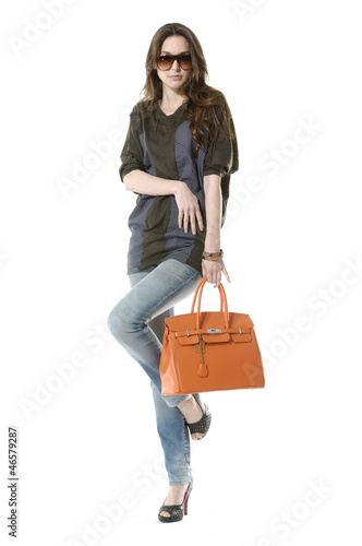 casual young fashion mode in sunglasses with handbag