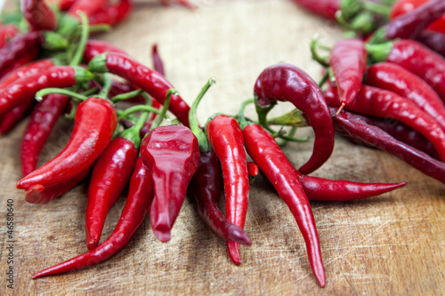 Red hot chili peppers on old wooden table