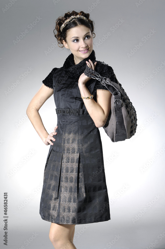 Fashion girl with handbag posing in the studio Fashion girl with handbag posing in the studio