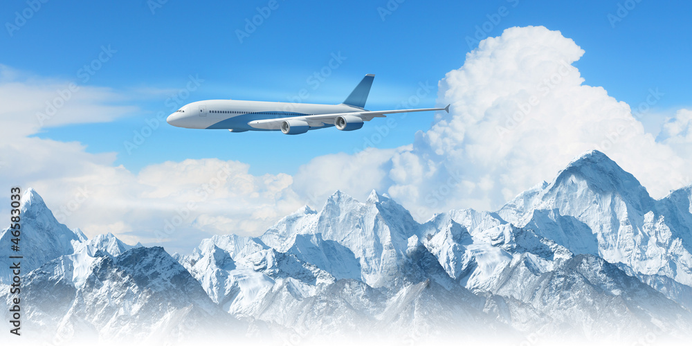 Fototapeta premium White passenger plane above the mountains