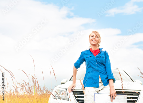 Tourist woman in front of car in summer field. © Konstantin Yolshin
