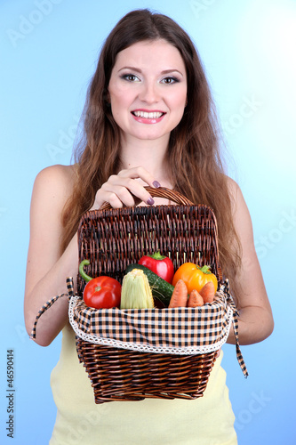 Beautiful woman with vegetables in wicker basket