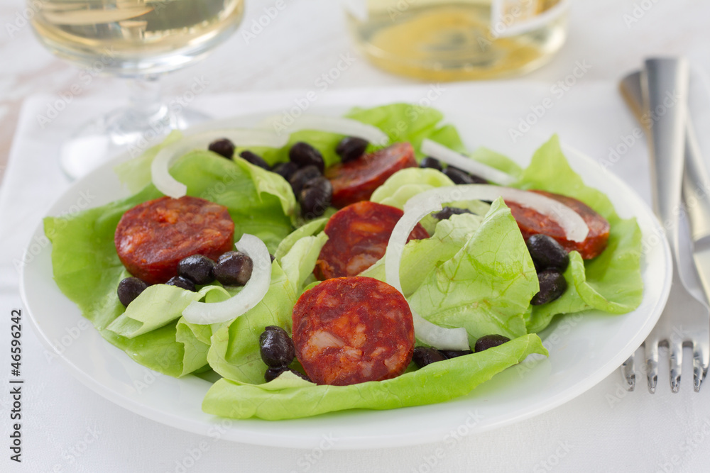 salad with sausages and beans on the white plate salad with sausages and beans on the white plate