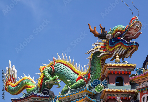 Colorful dragon statue on china temple roof. © Cozyta