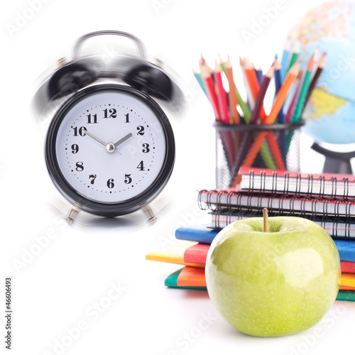 Alarm clock, notebook stack and pencils. Schoolchild and student