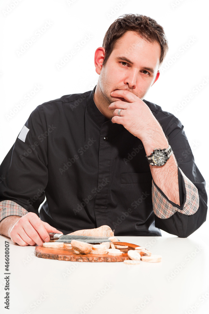 Male cook with black jacket preparing raw ingredients. Male cook with black jacket preparing raw ingredients.