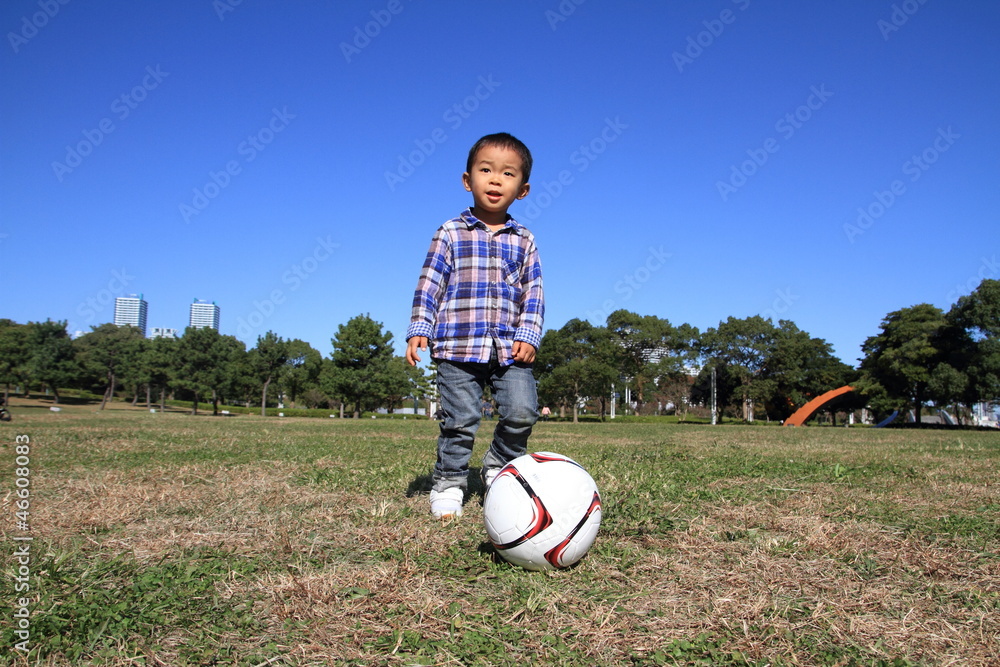 Fototapeta premium サッカーボールを蹴る幼児