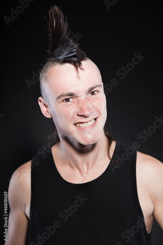 Punk rock man with mohawk haircut against black background. © ysbrandcosijn