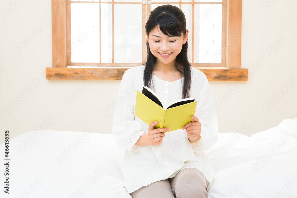 ベッドで本を読む女性