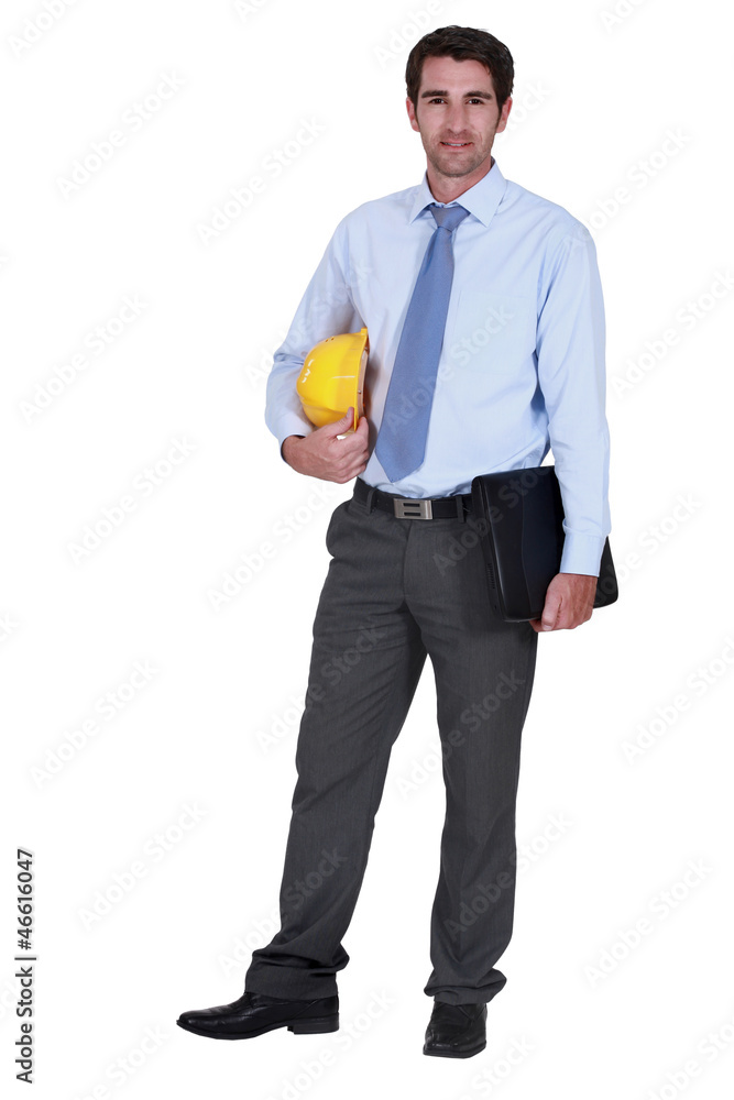 Architect stood with hardhat and folder under arm Architect stood with hardhat and folder under arm
