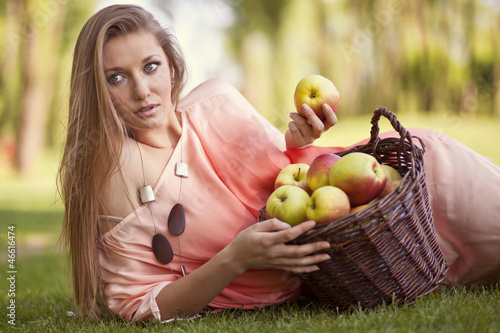 Piękna kobieta z koszem jabłek