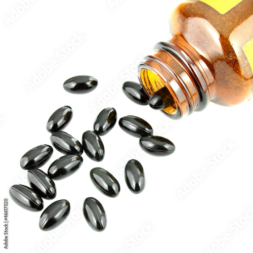black pills an pill bottle on white
