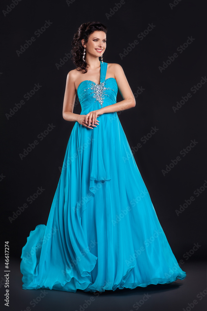 Fototapeta premium Portrait of trendy young woman in trendy blue dress smiling
