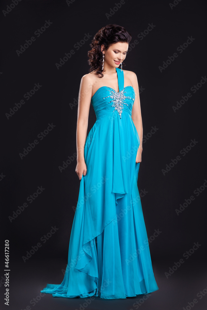Fashion style. Graceful woman in classic long cyan dress posing Fashion style. Graceful woman in classic long cyan dress posing