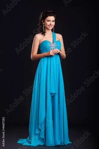 Portrait of trendy young woman in trendy blue dress smiling