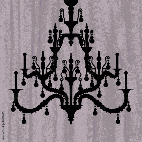 silhouette of luxury chandelier on a scratched purple wallpaper/